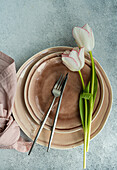 Place setting with brown pottery and tulips