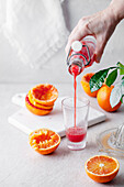 Freshly squeezed blood orange juice pouring into a glass