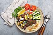 Falafel-Bowl mit Hummus, Gemüse, Oliven, Kräutern und Joghurtsauce