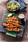 Chicken skewers with peanut sauce and mango-cucumber salad