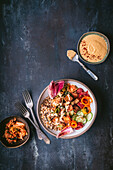 Farro tofu bowl with raw vegetables, kimchi and sauce