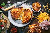 Golden brown grilled cheese sandwich with ham and chutney