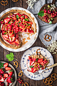 Strawberry Cream Pie and slice on plate with fresh berries and pretzels