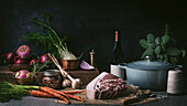 Still life with raw pork, fennel, carrots, turnips, onions and red wine