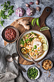 Hühnchen-Ingwer-Suppe mit Reisnudeln, Chilisauce, Ingwer und Knoblauch