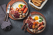 Traditional full English breakfast with fried eggs, sausages, beans, mushrooms, grilled tomatoes, bacon and toasts