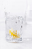 Lemon splashing into a glass of water