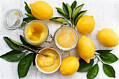 Lemon Curd in Gläsern und Zitronen mit Blättern