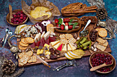 Appetizer board with caprese, cheese, crackers, fruit and pickles