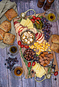 Käsebrett mit Obst, Oliven, Weintrauben und Brot