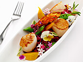 Fried scallops with vegetables and edible flowers