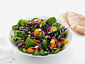 Spinach salad with carrots, red cabbage, mandarin wedges and sliced almonds