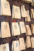 Adventskalender aus Papiertüten an Wand