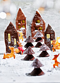 Gingerbread house biscuits with chocolate trees in the snow