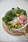 White asparagus with ham, early potatoes, and green sauce