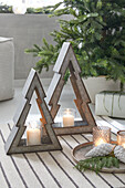 Christmas tree candle holder and tea lights on striped carpet next to Christmas tree