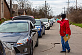 Volunteer directing queue of cars to a food bank