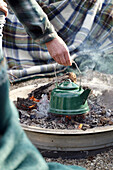 Teewasser auf dem offenen Feuer erhitzen