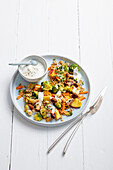 Raw vegetable salad with toasted oat flakes and nut yogurt