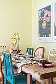 Set dining table with orchid, yellow walls and pictures