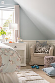 Attic bedroom with patterned textiles and light blue walls