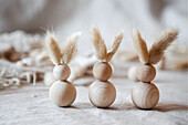 DIY-Osterhasen aus Holzkugeln mit Hasenohren aus Trockenblumen