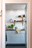 Modern kitchen with metro tiles and cabinet fronts in light grey