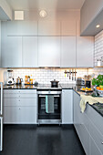 Modern kitchen with light grey cabinets and metro tiles