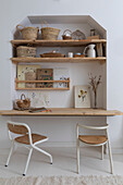 Workspace with wall shelves, baskets and botanical drawings