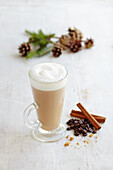 Latte coffee with spices ginger cinnamon on white wood