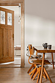 Wooden table and chairs in minimalist dining room with wooden doors