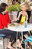 Two girlfriends eating outside