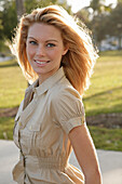 Blonde woman in light blouse dress outside