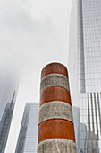 Dirty Orange And White Striped Construction Post With Skyscrapers In The Background; New York City, New York, United States Of America