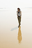 Junge Frau, die am Strand von Huohu, nördlich der Insel Kinsmen, spazieren geht; Huohu, Taiwan