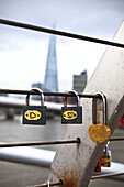 Locks Placed On The Railings Of The Millenium Bridge With The Shard In The Background; London, England