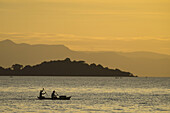 Silhouette von Fischern im Einbaum, die Cape Maclear am Abend verlassen, Malawisee; Malawi