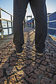 Man Standing On A Stone Walkway On The Waterfront; Locarno, Ticino, Switzerland