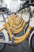 Gelbe und weiße Fahrräder in einer Reihe geparkt; Mailand, Lombardei, Italien