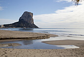 Ein zerklüfteter Felsgipfel entlang der Küste mit einem Strand und einem Gezeitentümpel im Vordergrund; Altea, Spanien