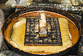 Kupferblockstempel, genannt Kappe, in heißem Wachs zum Auftragen auf einen Stoff bei der Herstellung von bedruckter Batik im Gunawan Setiawan Batik Shop, Kampung Kauman, Surakarta (Solo), Zentral-Java, Indonesien