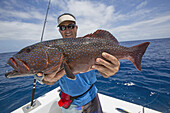Fisherman Holding A Fresh Caught Grouper (Epinephelinae); Tahiti