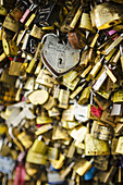 Vorhängeschlösser mit Liebesbotschaften an einer Brücke; Paris, Frankreich