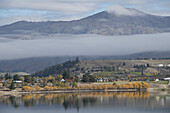 Wolken, die sich über eine Bergkette erstrecken, und der Ruataniwha-See im Vordergrund; Canterbury, Neuseeland