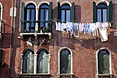 Saubere Wäsche, die an einer Wäscheleine vor einem Wohnhaus hängt; Venedig, Italien
