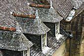 Close Up Of An Old Stone Tiled Roof With Three Dormitories; Morlaix, Brittany, France