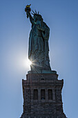 Sonnenuntergang hinter der Freiheitsstatue, Liberty Island; New York City, New York, Vereinigte Staaten von Amerika