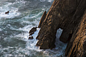 Surf Swirls Around The Base Of The Cliffs; Manzanita, Oregon, United States Of America