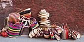 Woven Souvenirs On Display On A Sidewalk Against A Wall; San Miguel De Allende, Guanajuato, Mexico