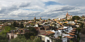 Stadtbild und Kirche in der Ferne unter bewölktem Himmel; San Miguel De Allende, Guanajuato, Mexiko